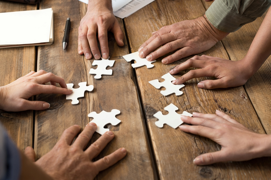Nahaufnahme Hände von Geschäftsleuten mit Puzzleteilen Nahaufnahme Hände von Geschäftsleuten mit Puzzleteilen