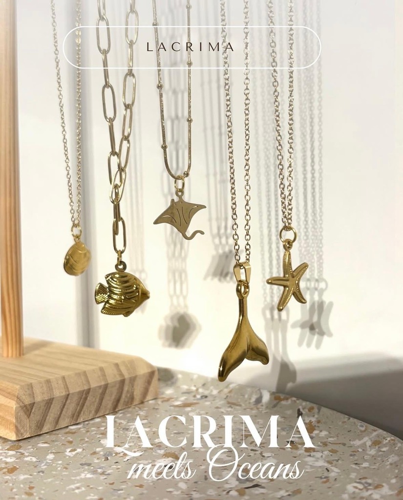 Bild von Lacrima, zu sehen ist goldener Schmuck mit Motiven aus dem Meer wie Rochen und Seesterne. Unten steht der Text "Lacrima meets Ocean""