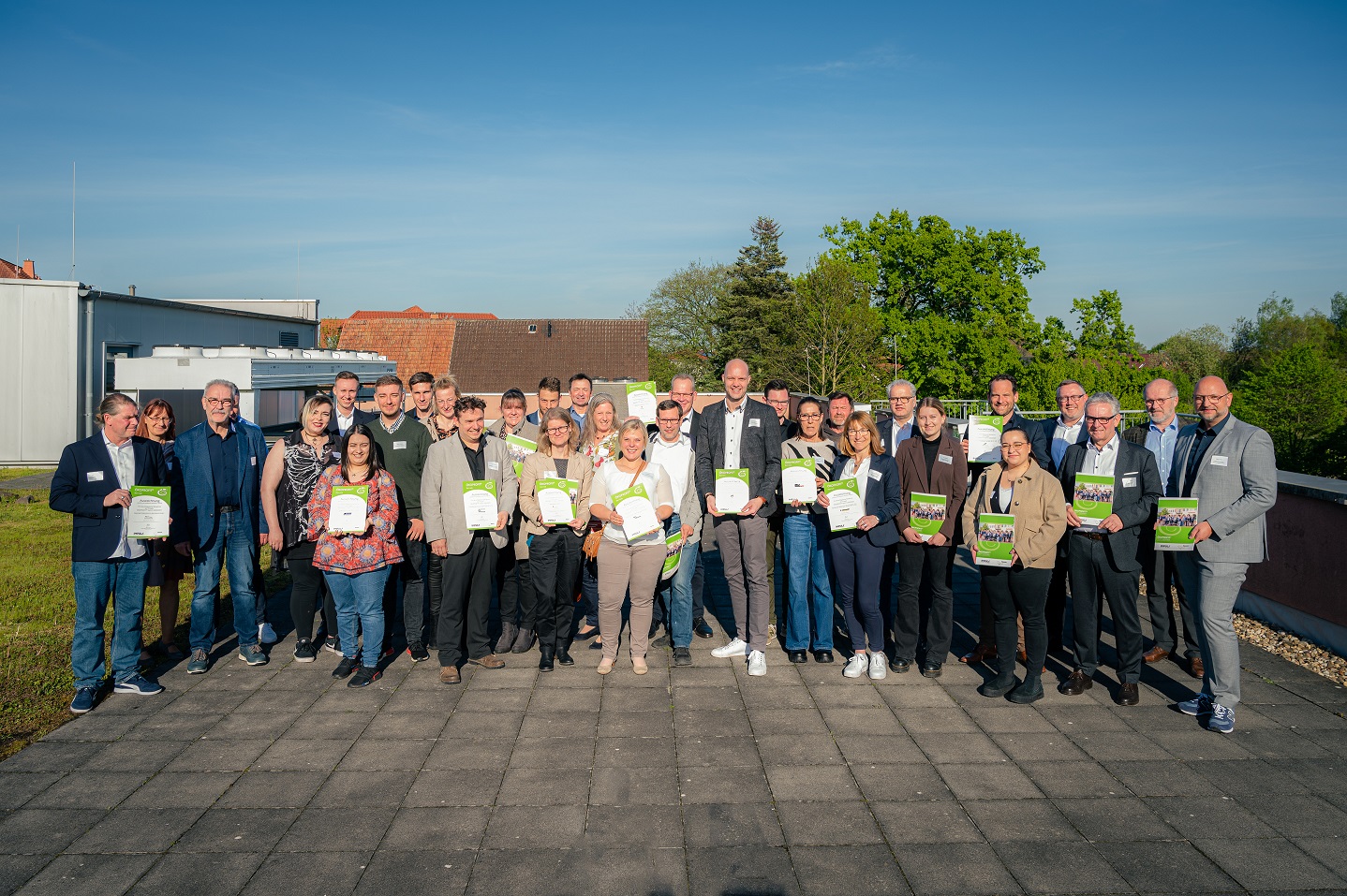 Auf dem Bild sind Vertreter:innen der Unternehmen zu sehen, die bei Ökoprofit ausgezeichnet wurden. Sie stehen auf der Dachterrasse der Westpress Arena.