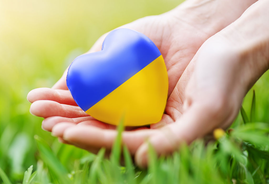 Frauenhände, die ein Herz in ukrainischen Farben halten