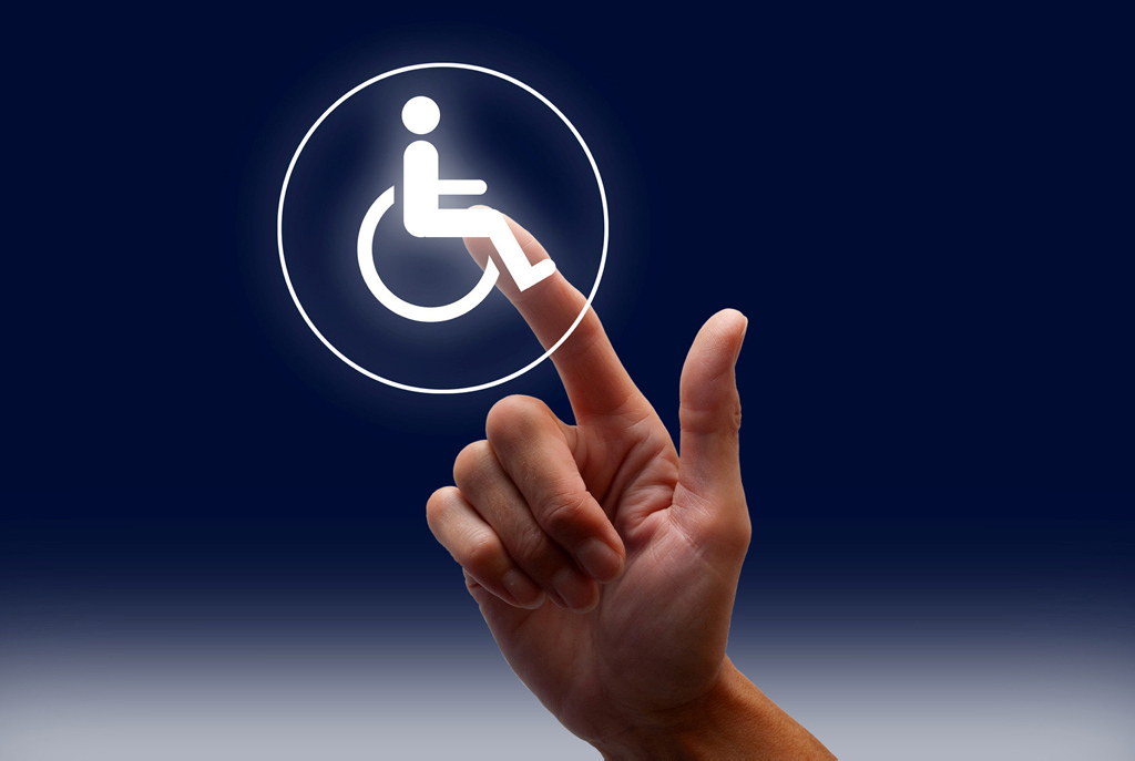 Ein Finger zeigt auf ein Rollstuhl-Symbol Ein Finger zeigt auf ein Rollstuhl-Symbol
