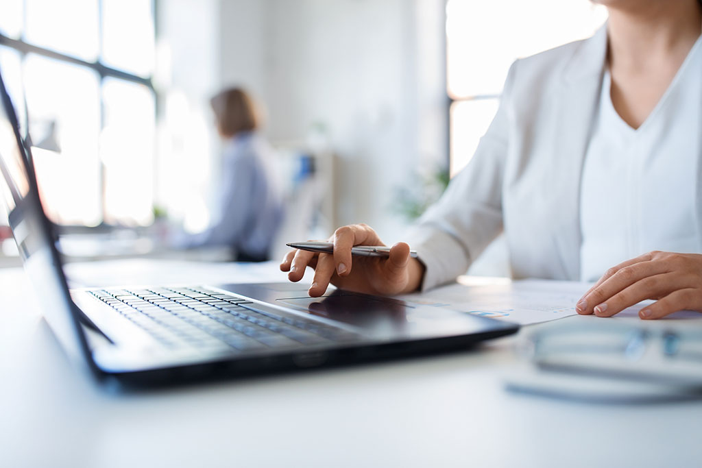 AdobeStock 274413590 Eine Geschäftsfrau arbeitet an einem Laptop