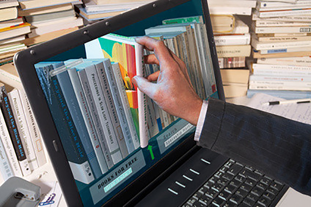 Fotolia 19418375 Sinnbild bei dem eine Hand in einen Bildschirm greift und ein Buch heraus nimmt