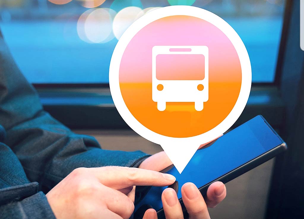 Ein Mann hält ein Handy und sucht eine Busverbindung