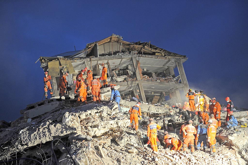 Rettungskräfte an einem zerstörten Wohnhaus