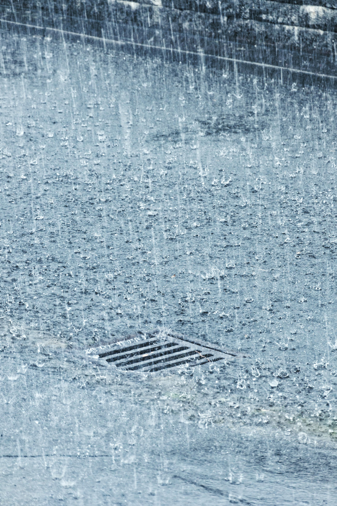 Starker Regen prasselt auf eine Stra&szlig;e nieder