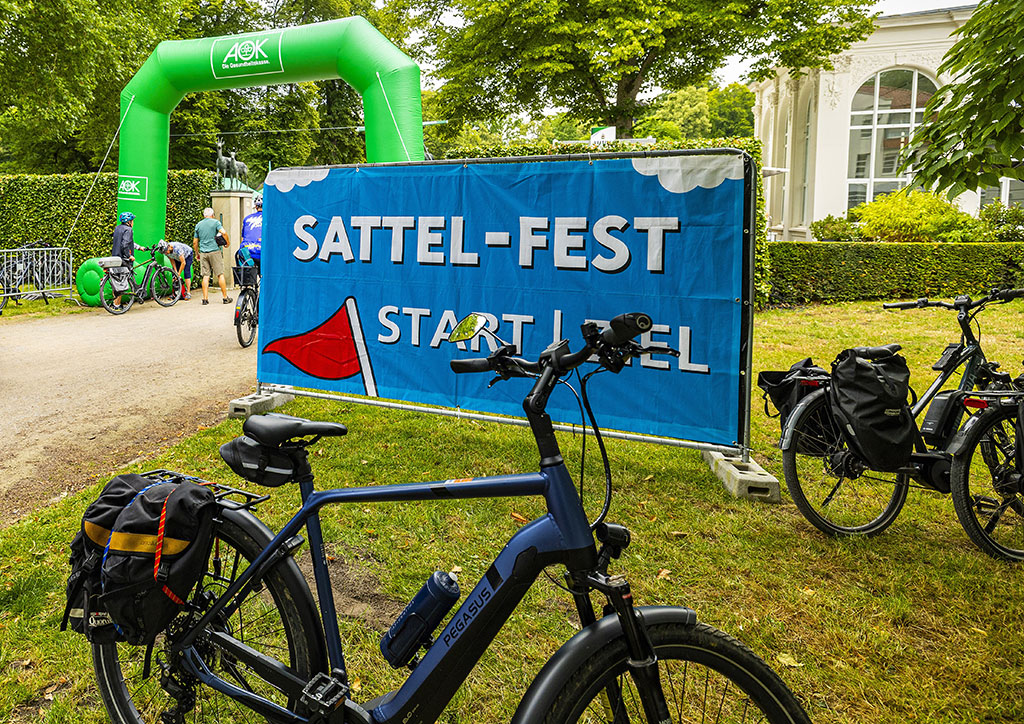 Ein Fahrrad vor einem Banner mit der Aufschrift Sattel-Fest am Kurhaus