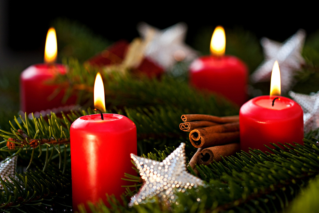Adventskranz mit vier roten brennenden Kerzen Adventskranz mit vier roten brennenden Kerzen
