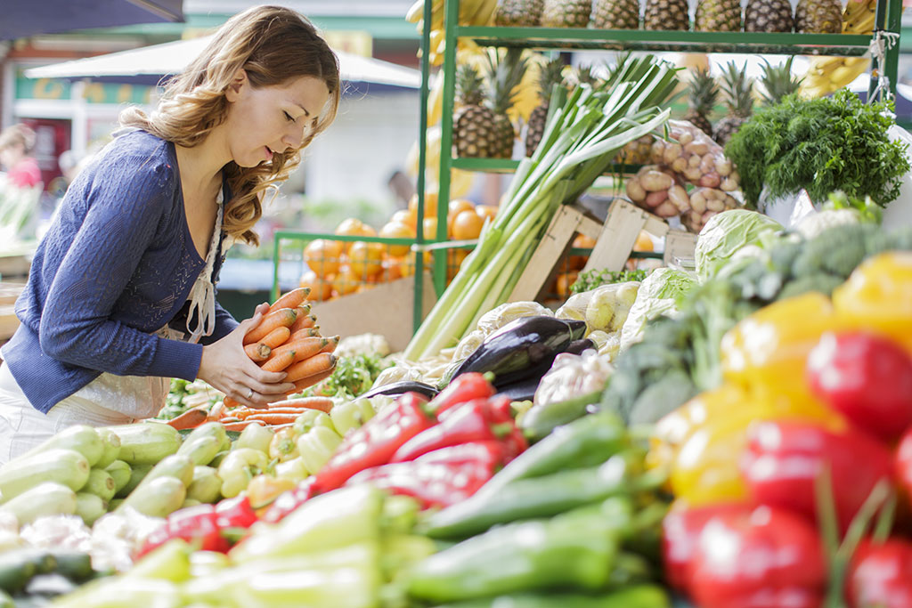 AdobeStock 58326817 eine Frau kauft Karotten auf dem Wochenmarkt