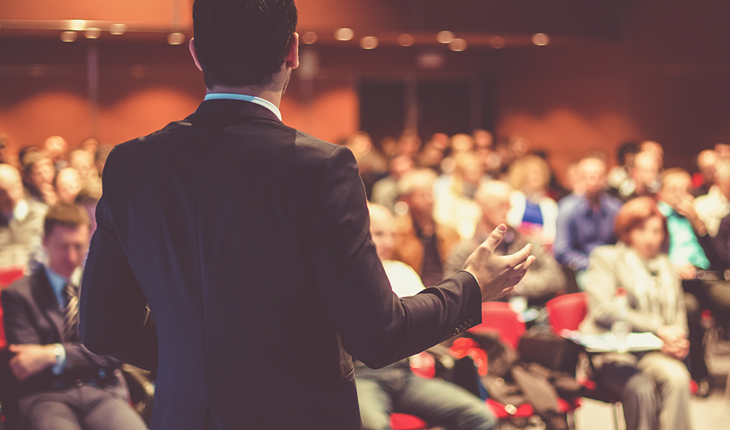 Ein Mann spricht auf einer Konferenz vor vielen Zuhörern